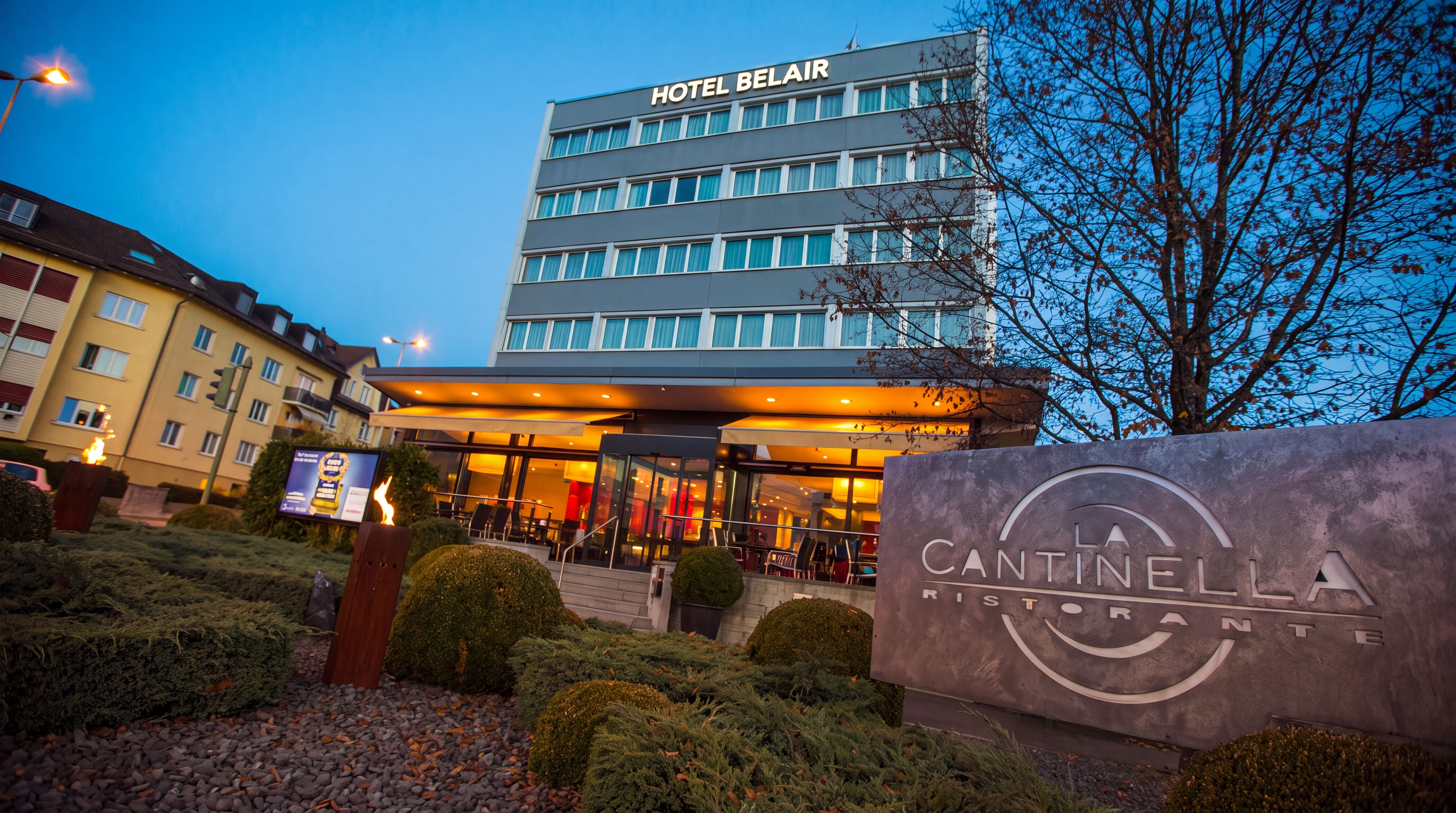 Beleuchteter Eingang und Vorplatz des Hotel Belair am Abend