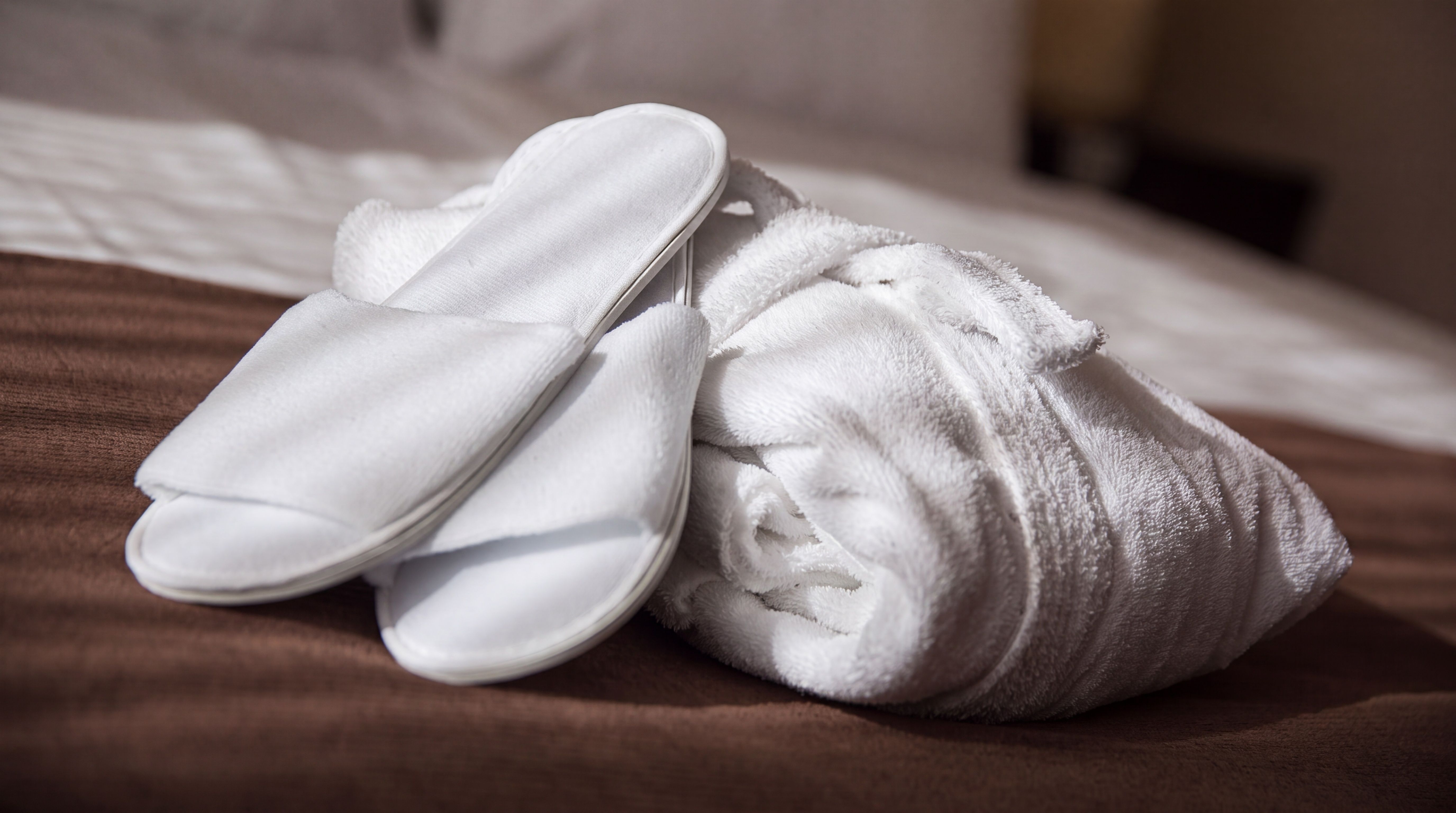 Bademantel und Slipper auf dem Bett, Hotel Belair Wallisellen