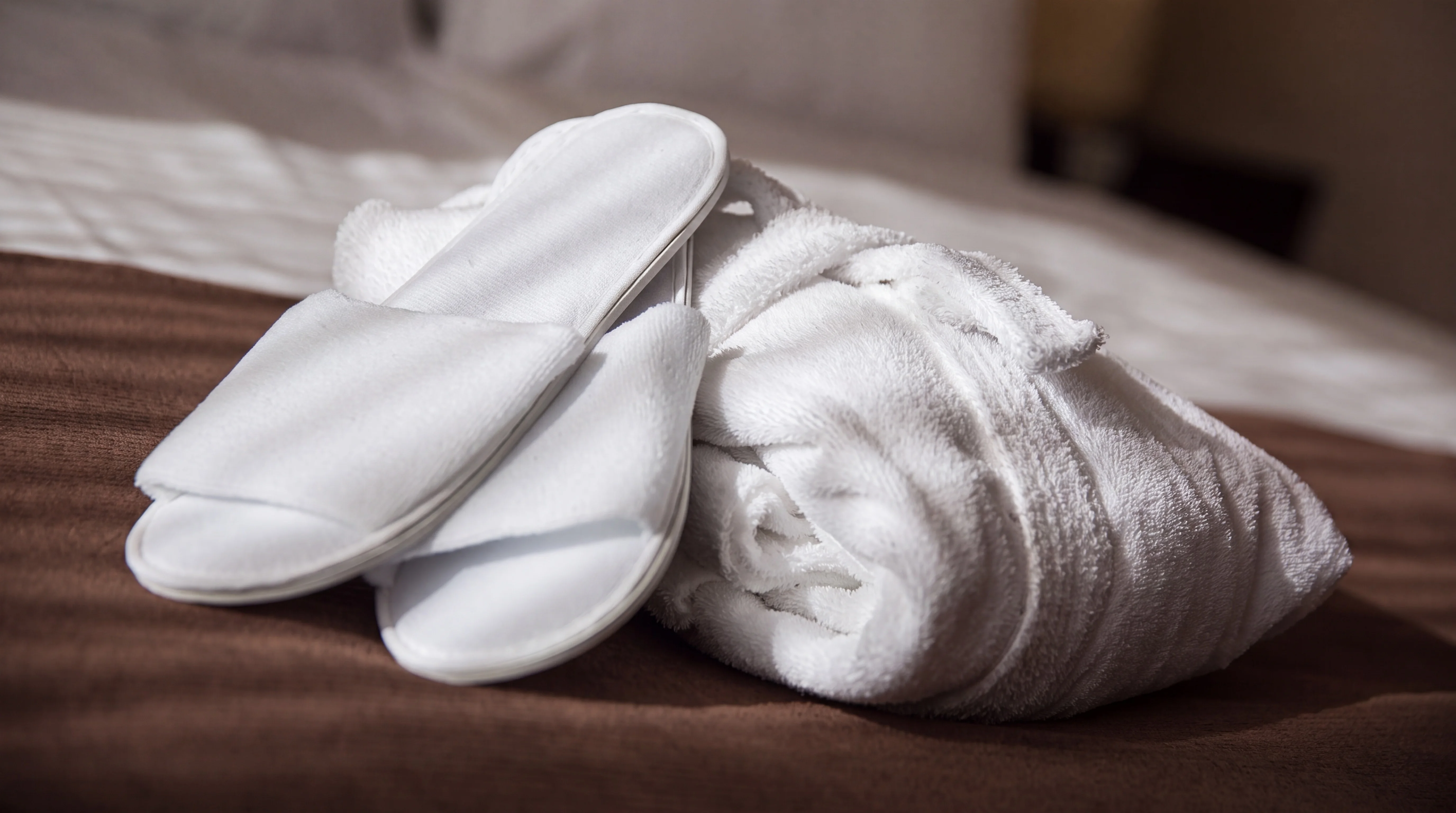 Bademantel und Slipper auf dem Bett im Businesszimmer
